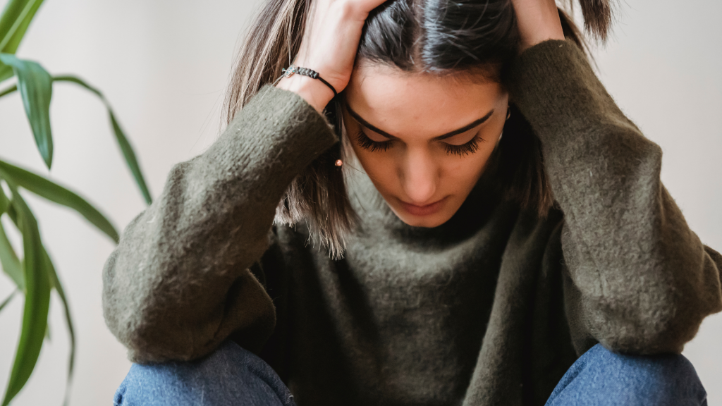 Woman with her head in her hand - Depression Counselling and Therapy Services are available in Toronto, Oakville, Hamilton and Virtually with The Therapy Centre