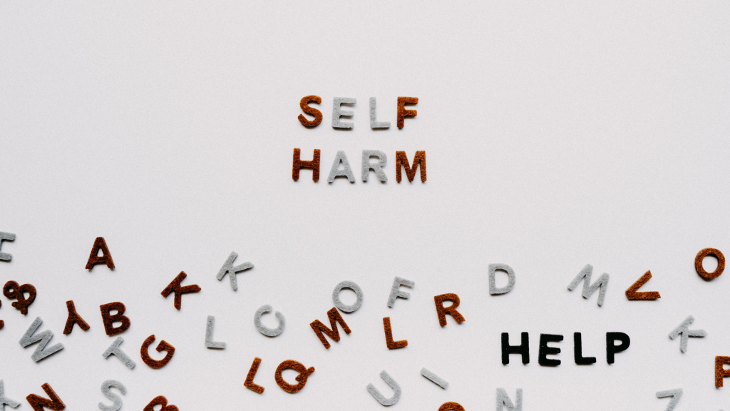 Words - self-harm and help with loose letters on table - Self-Harm Behaviour Therapy is available at The Therapy Centre with locations in Toronto, Oakville and Hamilton (GTA)