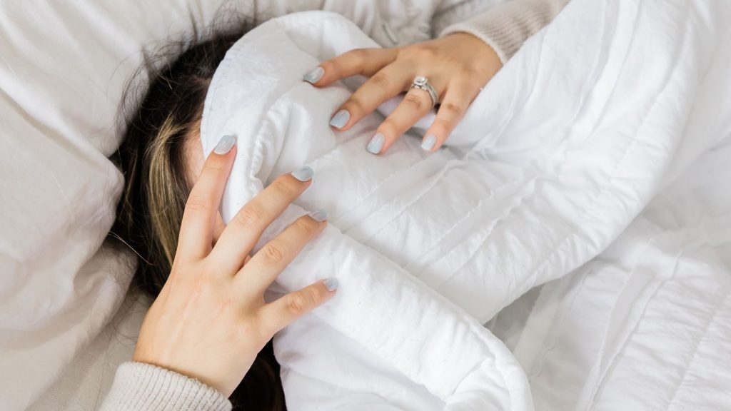 woman with sheets pulled over her head - Sleep Therapy is available at The Therapy Centre with locations in Toronto, Oakville and Hamilton (GTA)