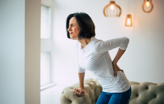 Woman with back problems - Managing Chronic Pain - How Therapy Can Improve Your Mental Health Article by The Therapy Centre