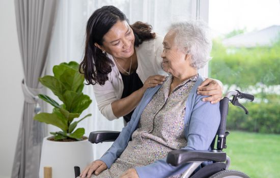 Woman Smiling at an Elderly Woman - The Stress of Being a Caregiver: Finding Support for Your Mental Health - Article by The Therapy Centre